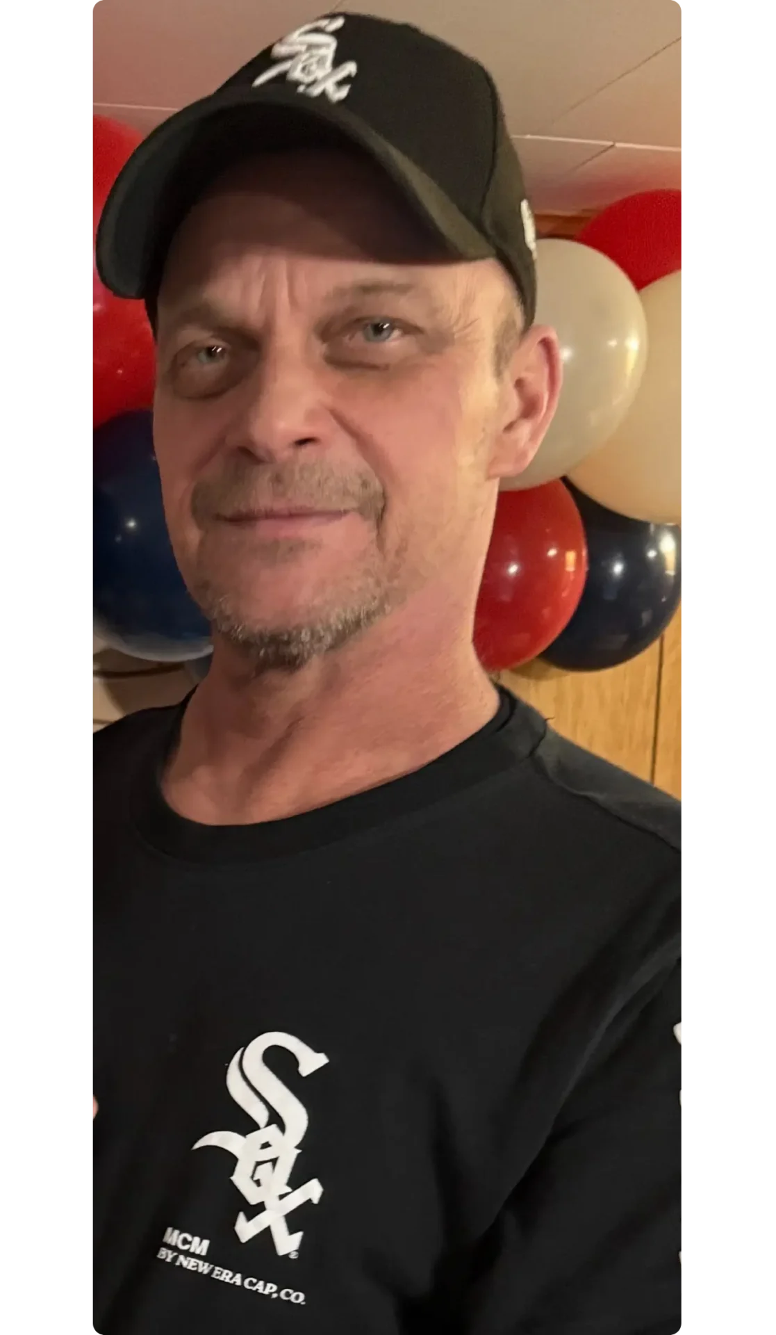 A man wearing a black shirt and baseball cap.